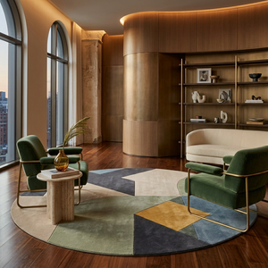Quadra round wool rug in a warm luxury lounge with green velvet chairs and brass accents