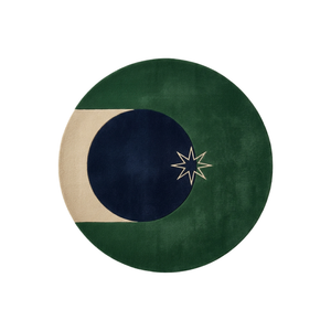 Polaris minimalist round wool rug in forest green and navy with a cream eight-point star, hand tufted by Rugfine